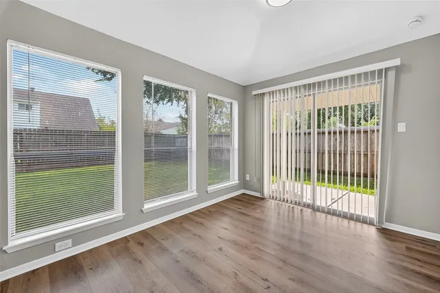 a view of a room with wooden floor and a large window