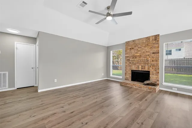 an empty room with windows and fan