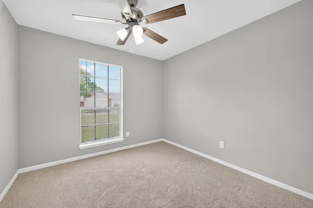 an empty room with a chandelier fan
