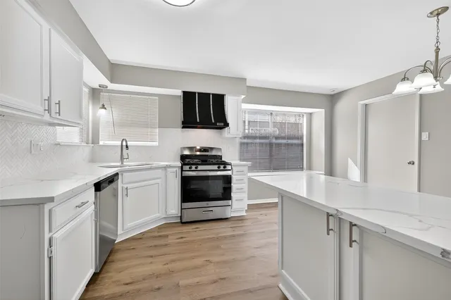 a kitchen with stainless steel appliances a stove a sink and a microwave