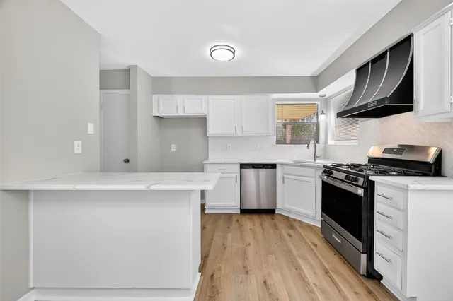 a kitchen with stainless steel appliances a stove a sink dishwasher and a refrigerator