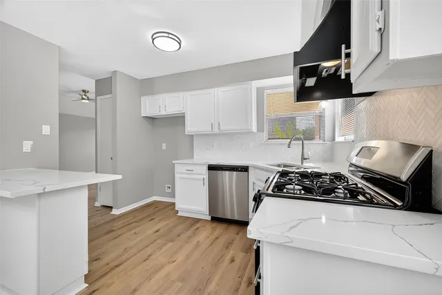 a kitchen with a stove cabinets and wooden floor