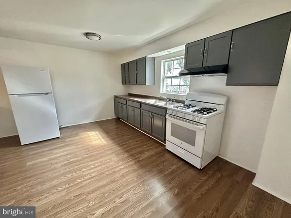 a kitchen with wooden floors and white appliances