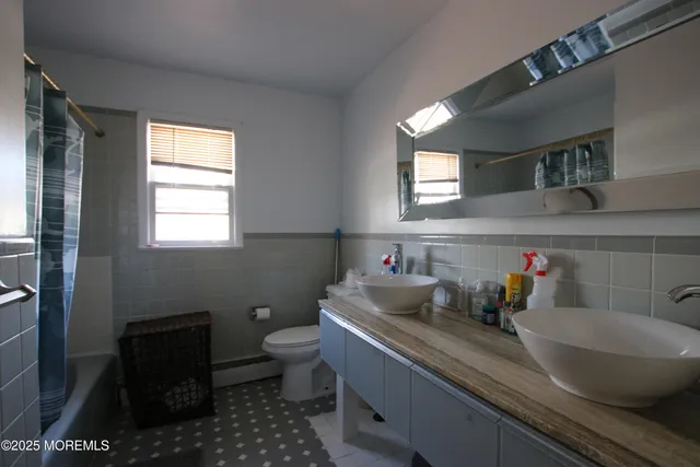 a bathroom with a sink a toilet and a window