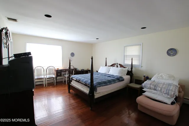 a bedroom with furniture and wooden floor