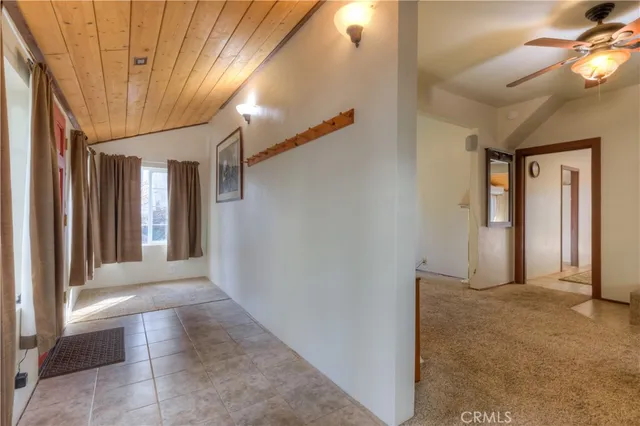 an empty room with ceiling fan and window