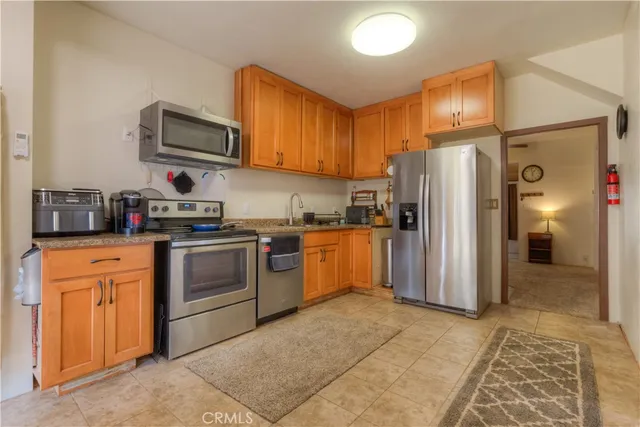 a kitchen with stainless steel appliances granite countertop a stove a sink dishwasher and a microwave oven with white cabinets
