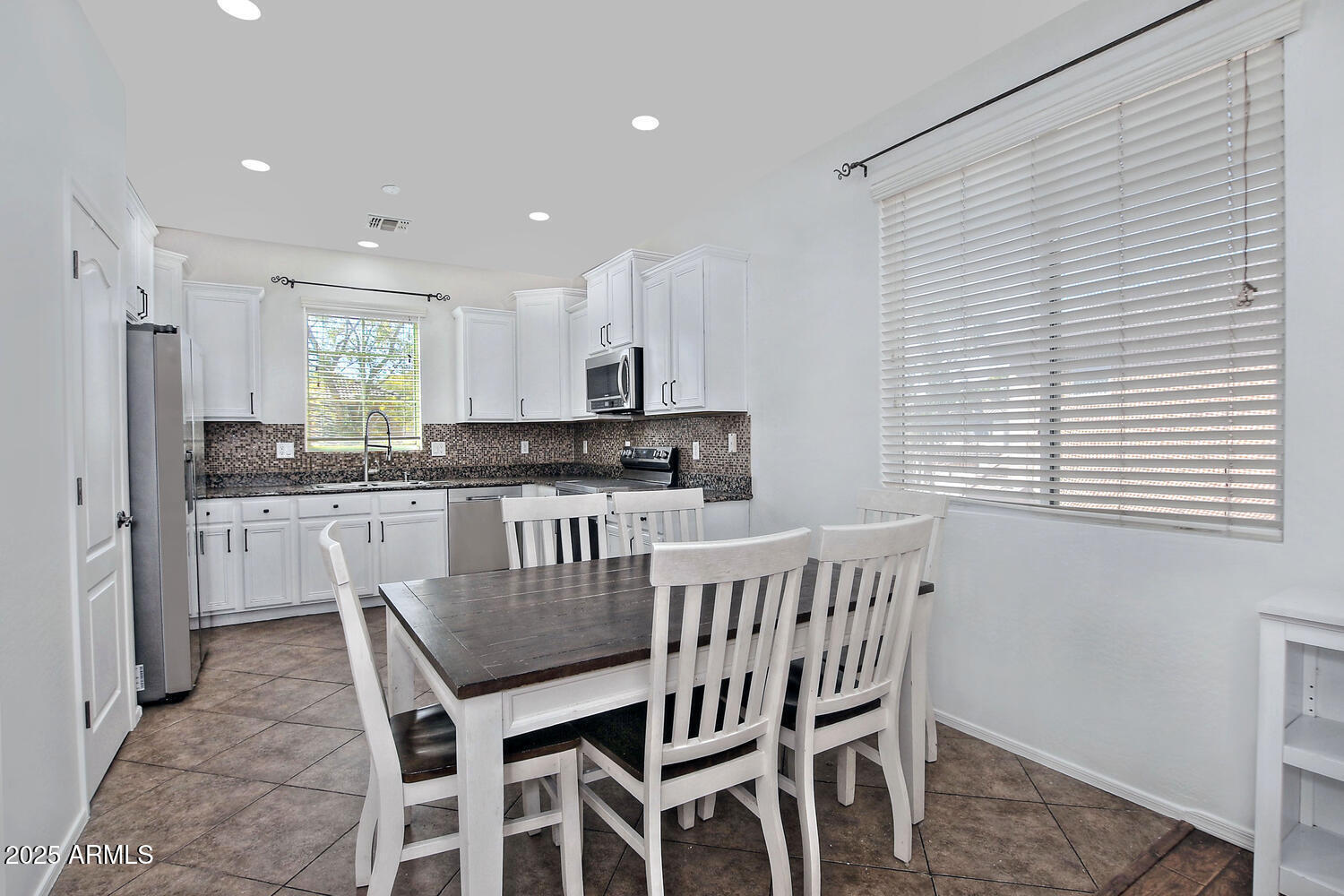 4232 East Tyson Street Gilbert, AZ 85295 - Photo 6 of 38 a kitchen with stainless steel appliances granite countertop a dining table chairs refrigerator a sink and dishwasher