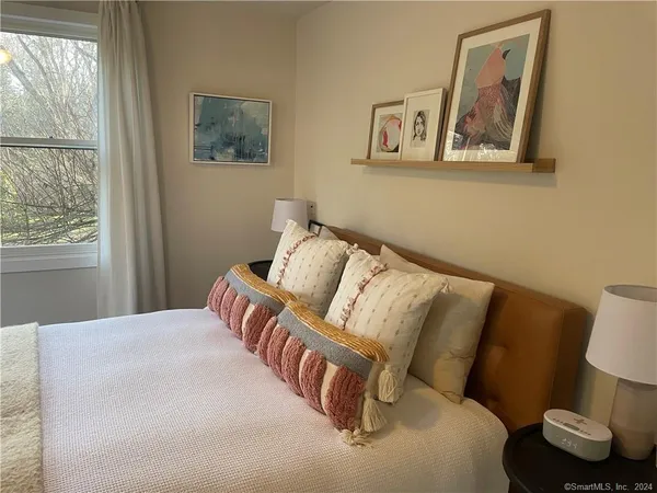a bedroom with a bed and a painting on the wall