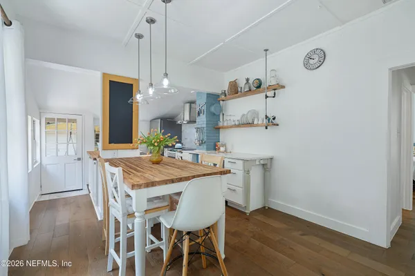 a kitchen with stainless steel appliances granite countertop a table chairs and a refrigerator