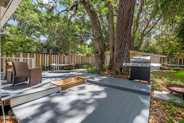 a view of a yard with wooden fence and a large tree