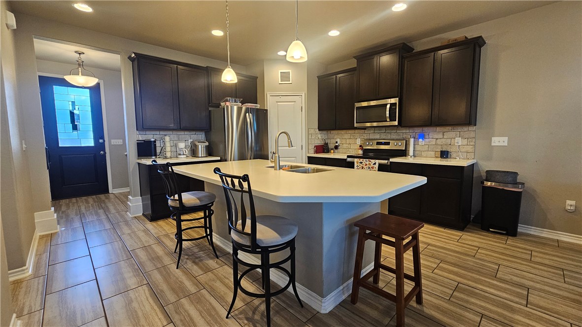 1051 Ocean Breeze Portland, TX 78374 - Photo 2 of 37 a kitchen with stainless steel appliances a sink a table and chairs in it