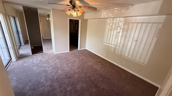 a view of a room with a windows and ceiling fan