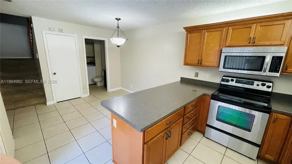 a kitchen with granite countertop a stove cabinets and microwave
