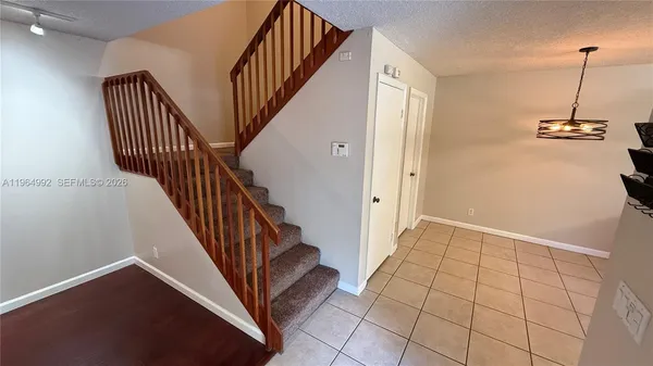 a view of a hallway with stairs and furniture