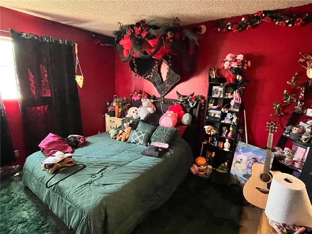a bedroom with a bed purple white bedspread and pillows