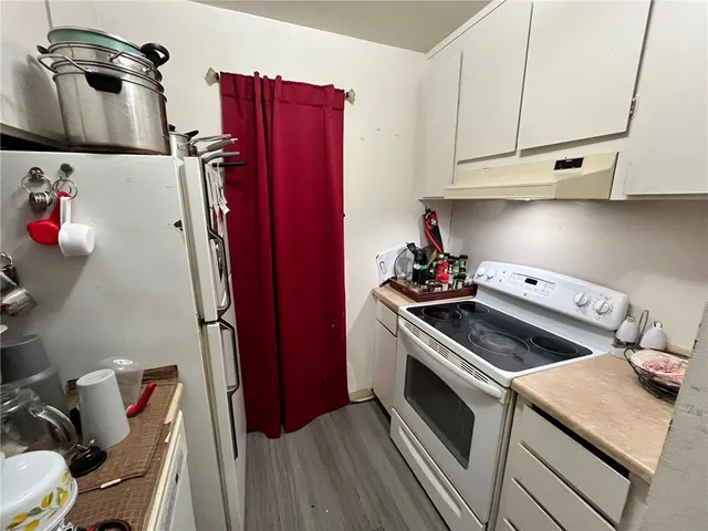 a kitchen with granite countertop a stove and a refrigerator