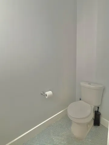 a view of an empty room with a chandelier fan