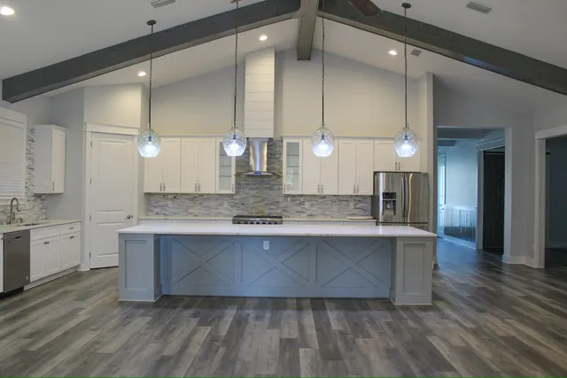 a large kitchen with kitchen island a sink stainless steel appliances and cabinets