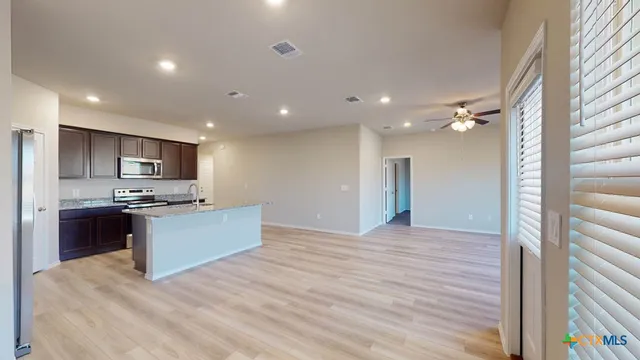 a large kitchen with kitchen island a sink stainless steel appliances and cabinets