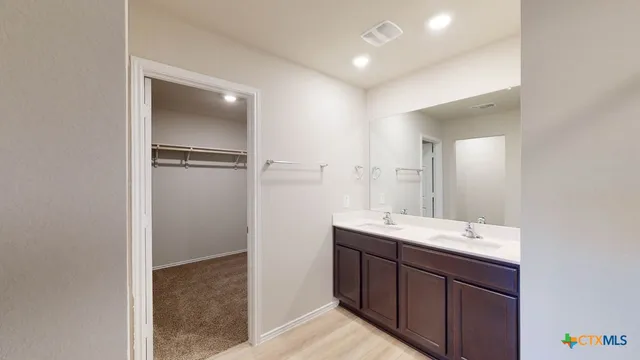 a bathroom with a double vanity sink and mirror