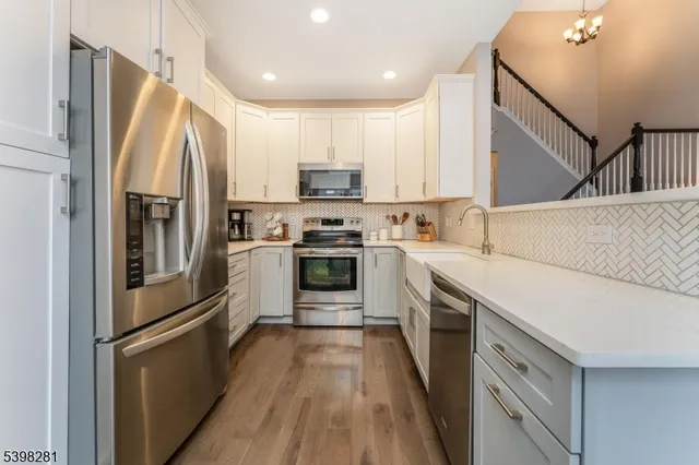 a kitchen with stainless steel appliances a refrigerator sink and microwave