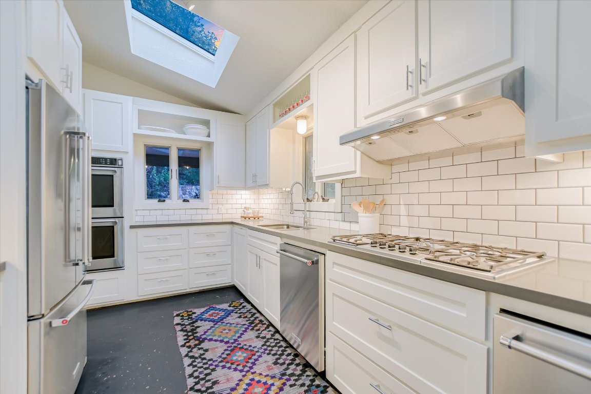 1121 Hidden Valley Road Wimberley, TX 78676 - Photo 16 of 40 a kitchen with stainless steel appliances kitchen island granite countertop a sink and cabinets