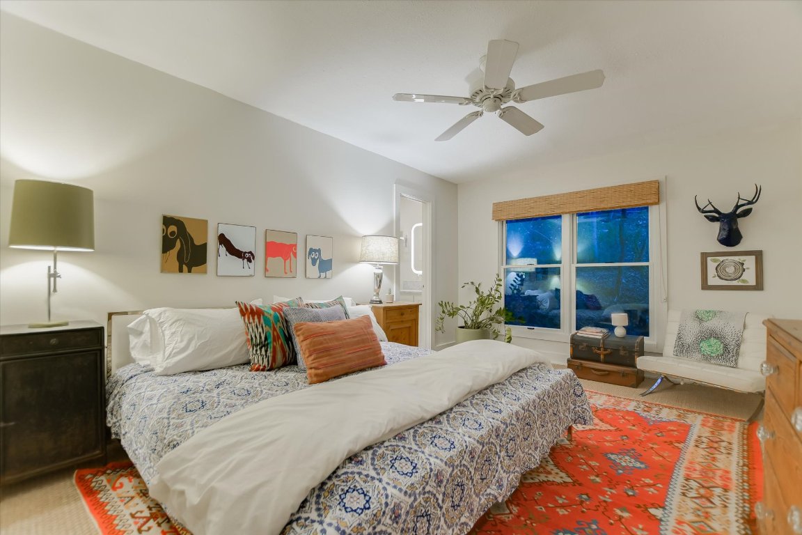 1121 Hidden Valley Road Wimberley, TX 78676 - Photo 19 of 40 a bedroom with a bed and ceiling fan