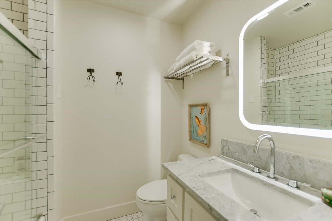 1121 Hidden Valley Road Wimberley, TX 78676 - Photo 20 of 40 a bathroom with a granite countertop sink toilet and shower