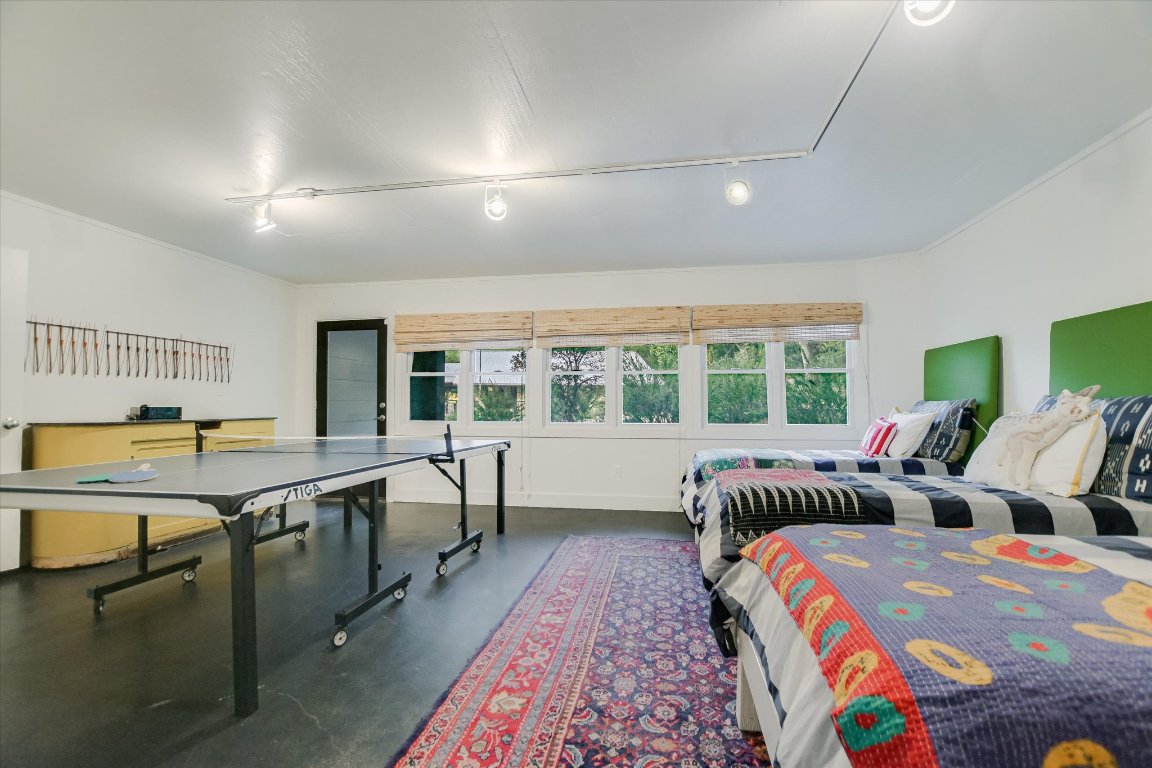 1121 Hidden Valley Road Wimberley, TX 78676 - Photo 36 of 40 a large bedroom with three beds and a large window