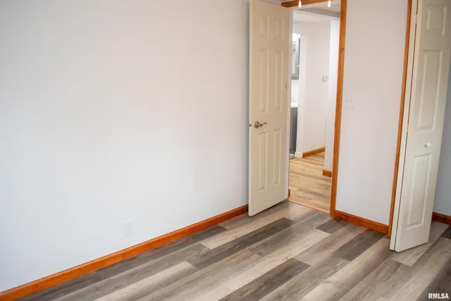 a view of a room with wooden floor and white walls