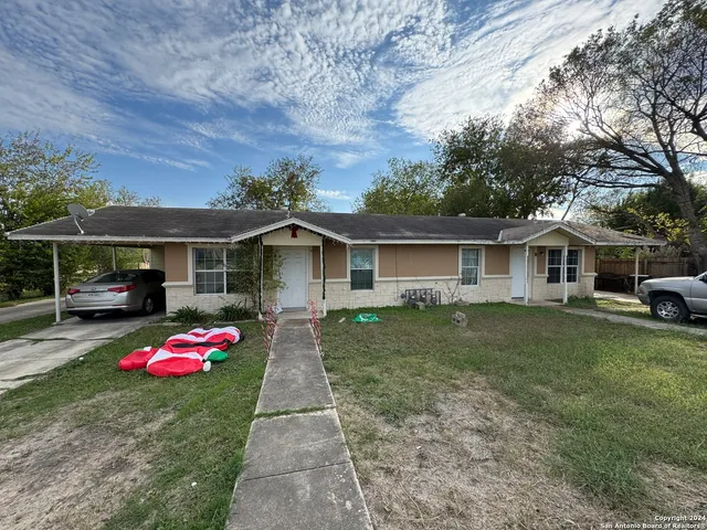 a backyard of a house with table and chairs