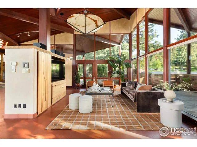 a living room with furniture a large window and stainless steel appliances