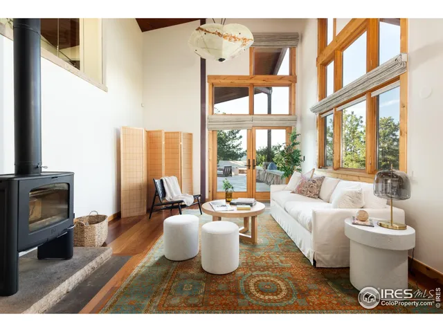 a living room with furniture a large window and a fireplace