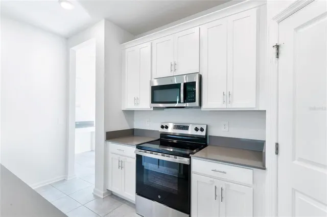 a kitchen with white cabinets and stainless steel appliances