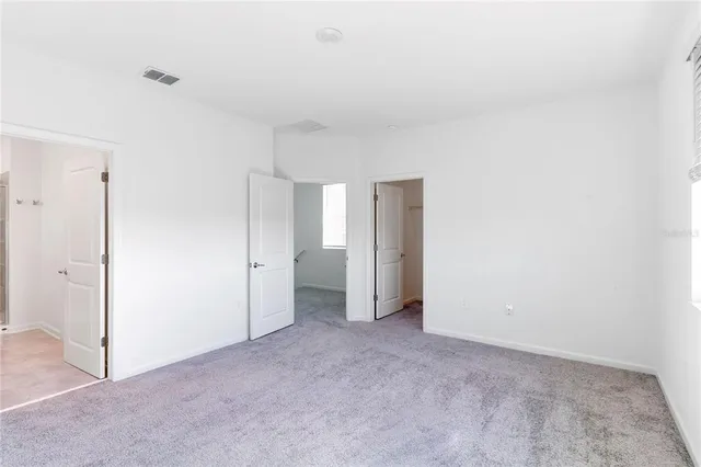 an empty room with windows and closet