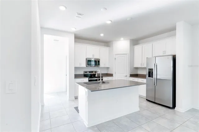 a kitchen with white cabinets and stainless steel appliances