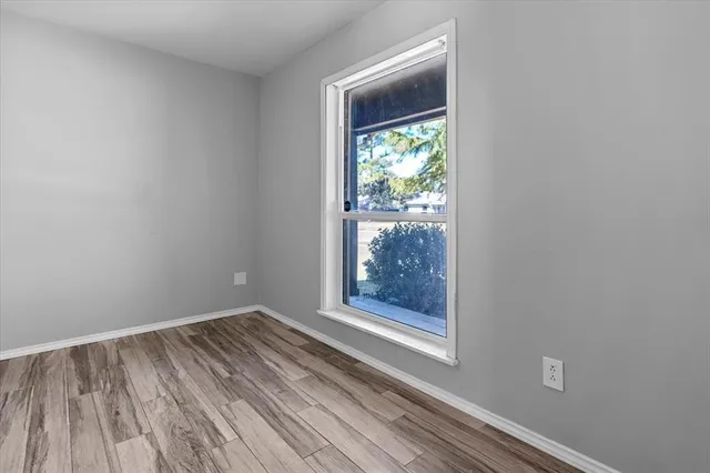 a view of a small space with wooden floor and a window