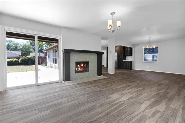 a view of an empty room with a window and a fireplace