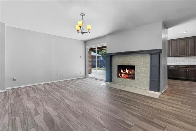 an empty room with wooden floor and fireplace
