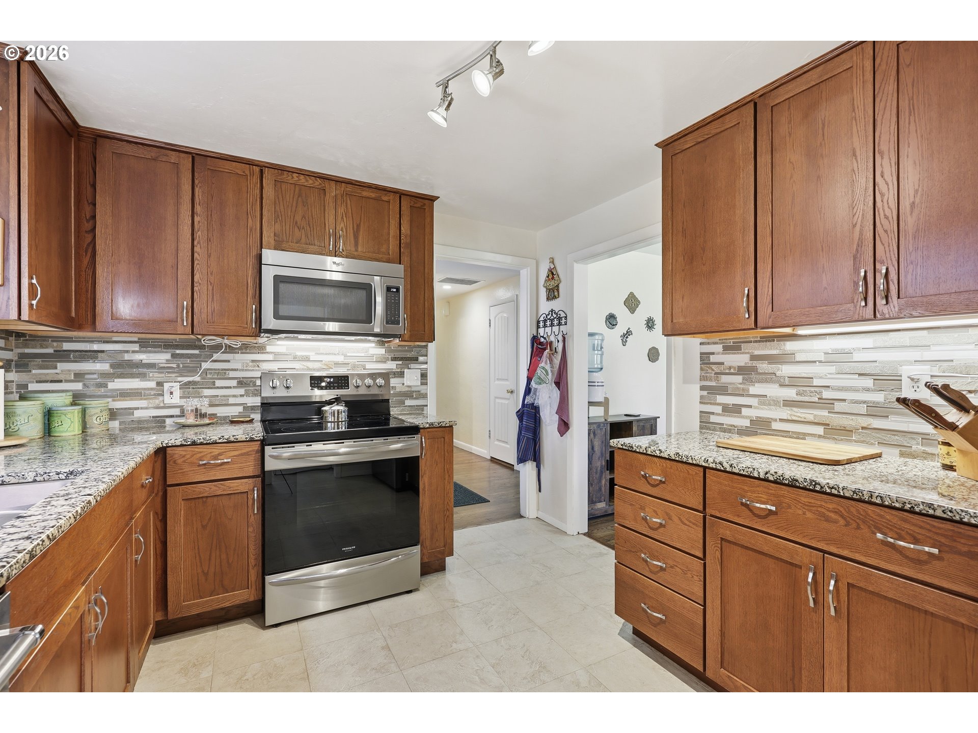 65 Greenvale Drive Springfield, OR 97477 - Photo 15 of 42 a kitchen with stainless steel appliances granite countertop a stove top oven a sink dishwasher and a refrigerator with wooden cabinets