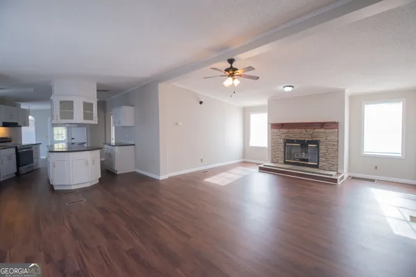 a view of empty room with wooden floor and fireplace