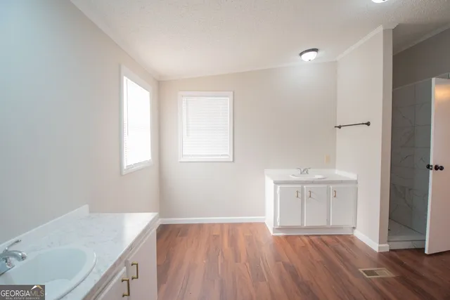 a view of a kitchen with wooden floor and a sink