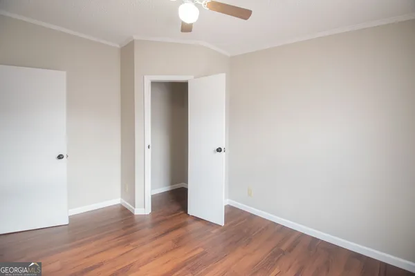 a view of an empty room with wooden floor