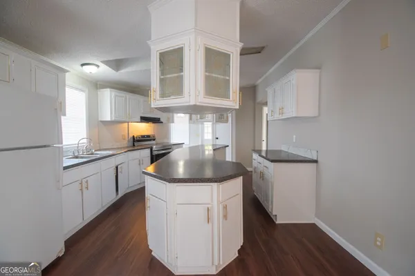 a kitchen with sink cabinets and wooden floor