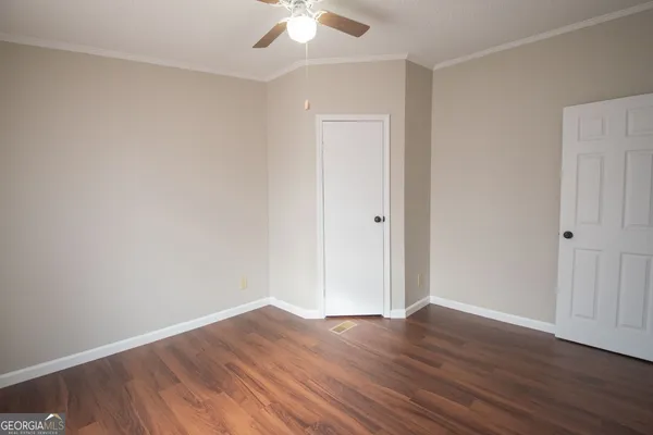 a view of an empty room with wooden floor