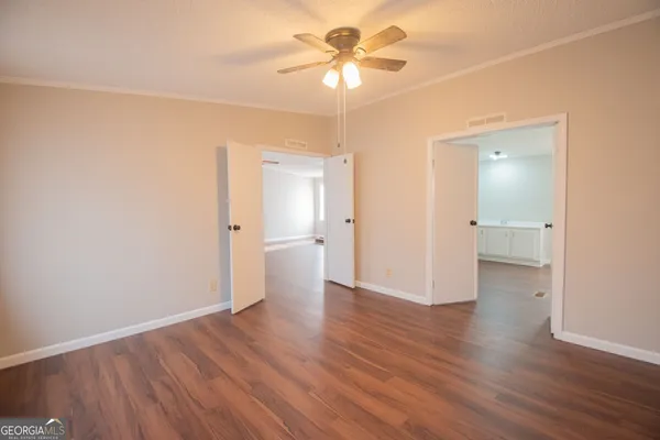 a view of a room with wooden floor and a ceiling fan