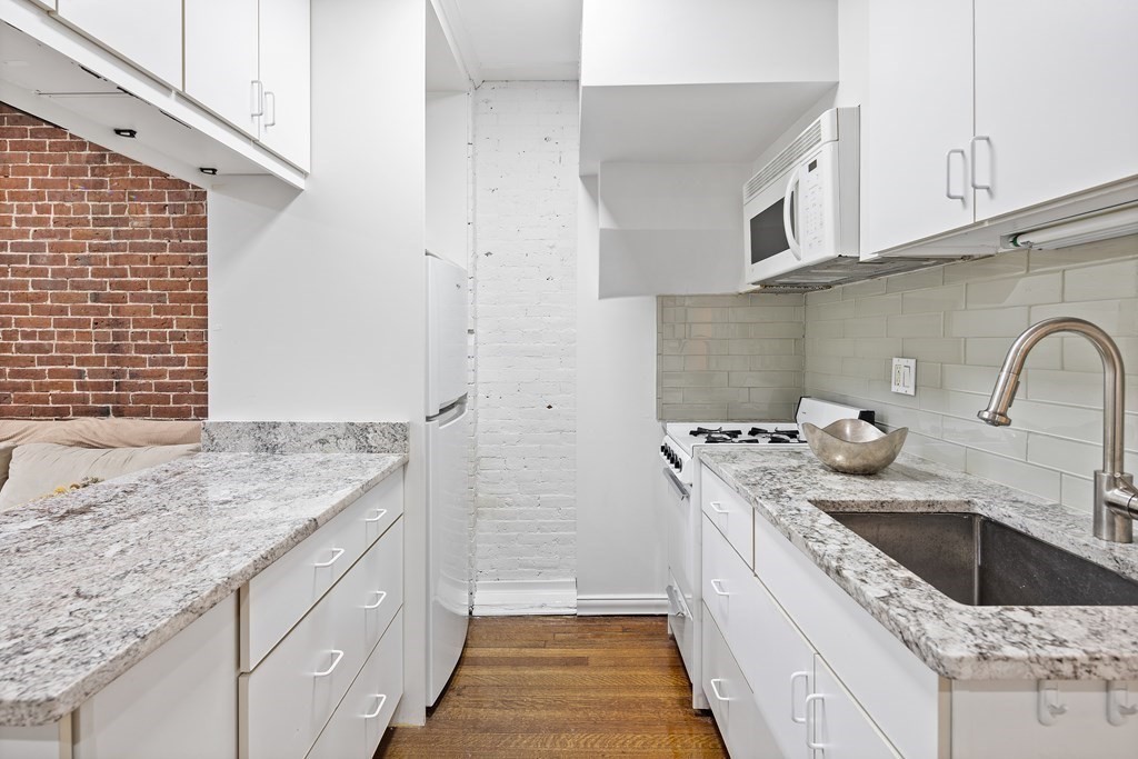338 Beacon Street, Unit A Boston, MA 02116 - Photo 8 of 17 a kitchen with stainless steel appliances granite countertop a sink stove and cabinets