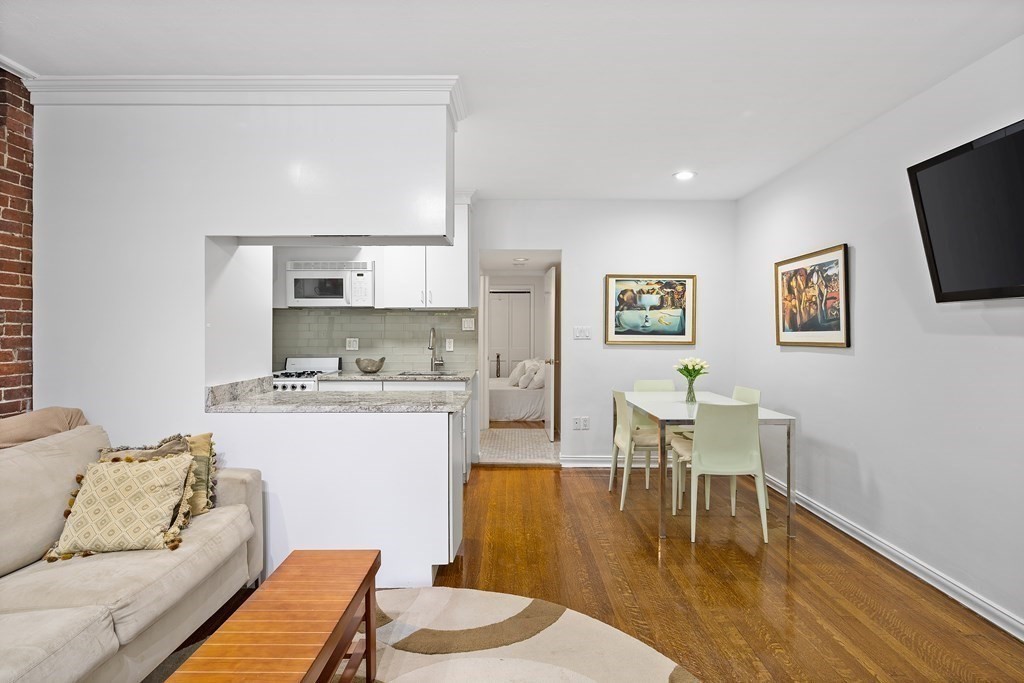 338 Beacon Street, Unit A Boston, MA 02116 - Photo 10 of 17 a living room with stainless steel appliances kitchen island granite countertop furniture and a wooden floor