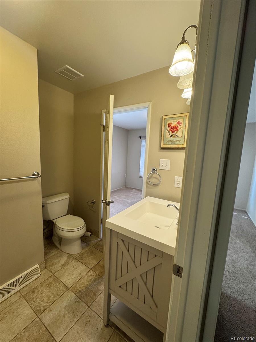 2524 South Oneida Street Denver, CO 80224 - Photo 8 of 11 a bathroom with a sink a toilet and vanity